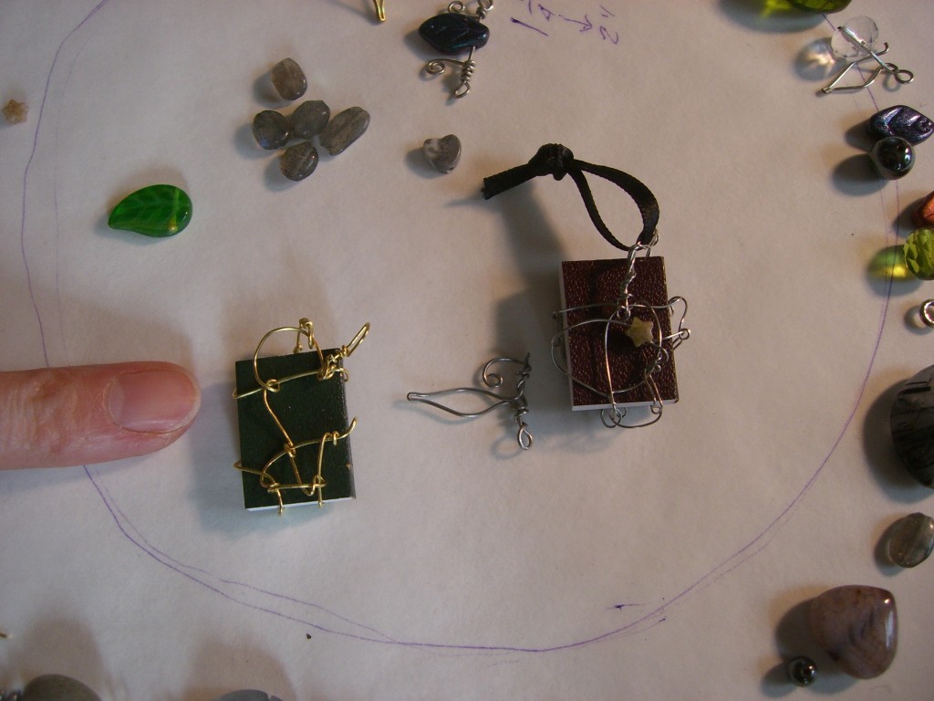 Two TINY BOOKS wrapped in wire, to be used as pendants.